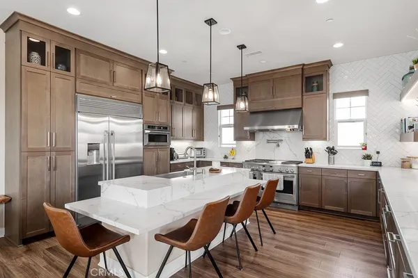 a kitchen with stainless steel appliances granite countertop a kitchen island a stove a table and chairs