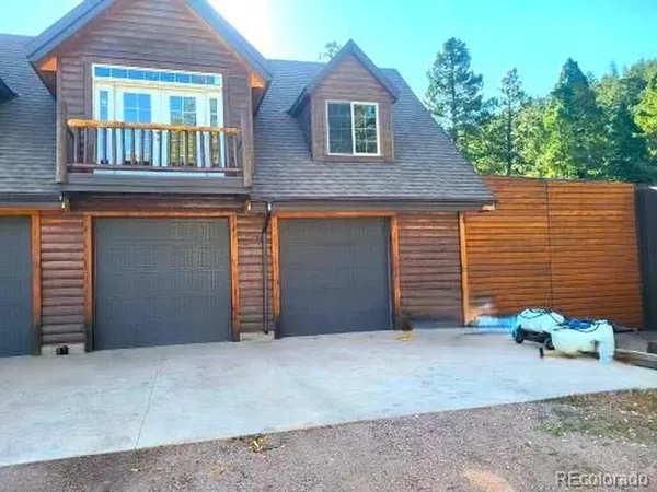 a brick house with a small yard and large tree