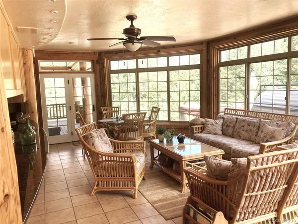 a living room with furniture and floor to ceiling windows