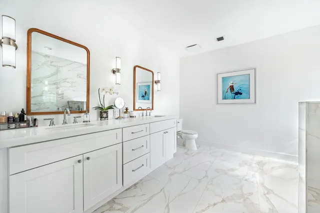 a bathroom with a double vanity sink toilet and a window