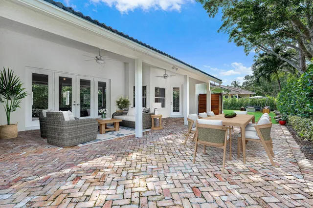 a view of a patio with a dining table and chairs with wooden fence