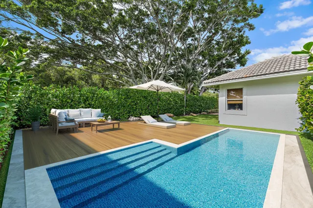 a view of a house with pool and chairs