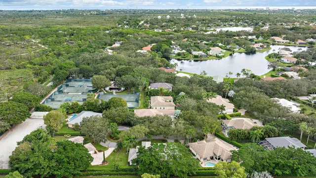 an aerial view of residential houses with outdoor space and trees