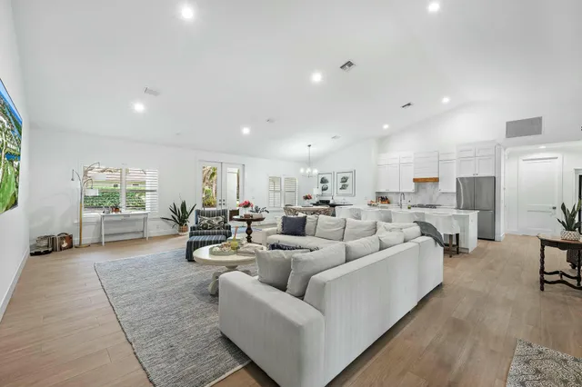 a living room with furniture white walls and kitchen view