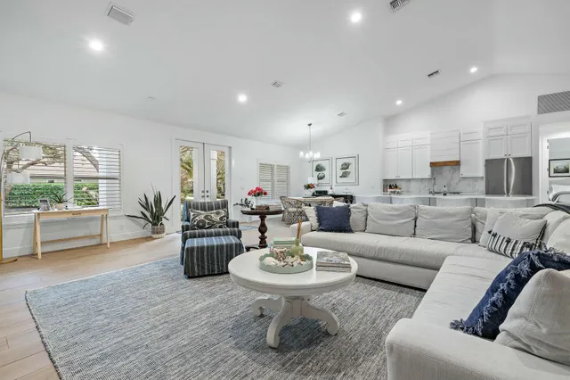 a living room with furniture and a dining table with kitchen view