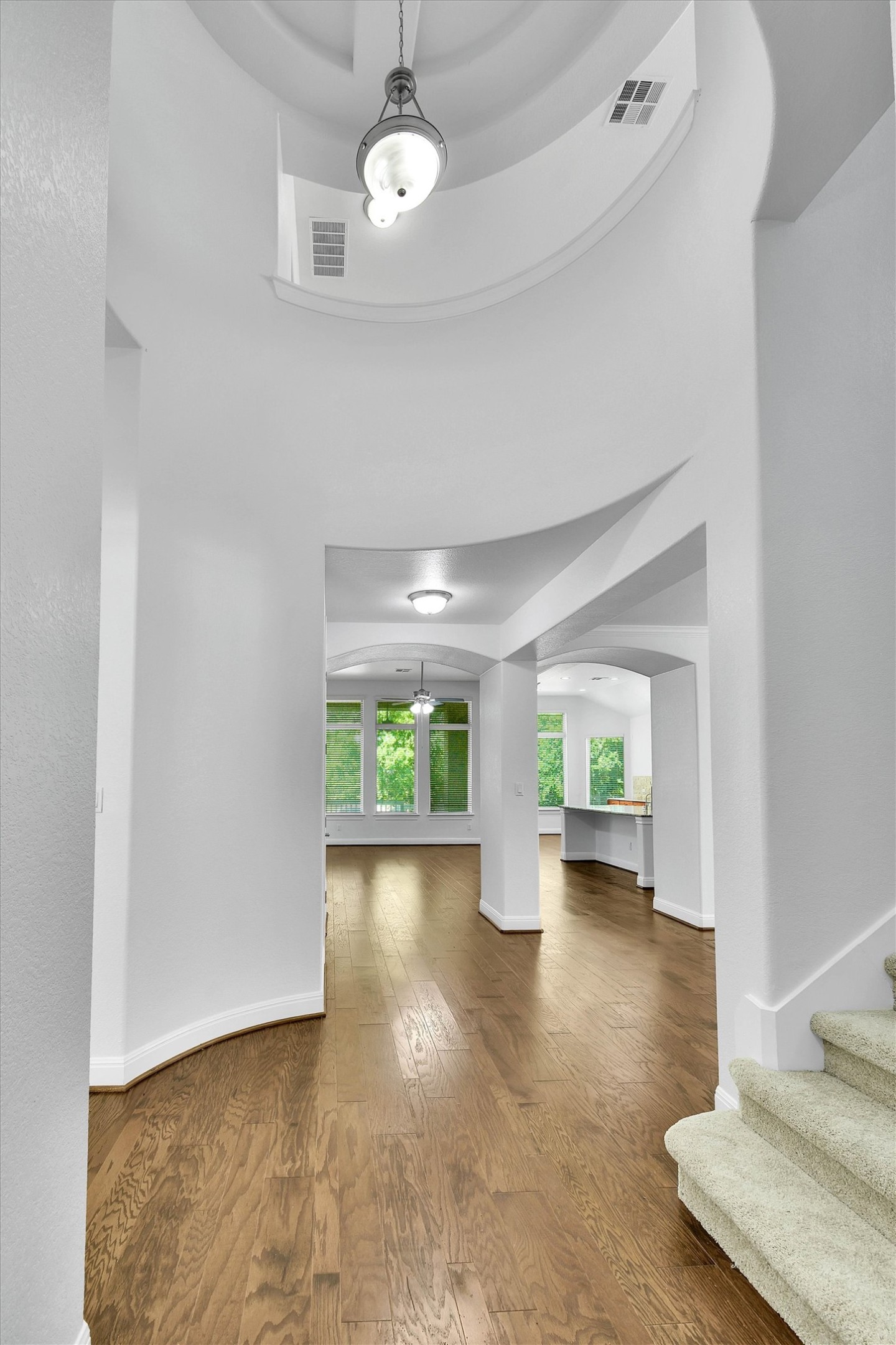 2325 Blended Tree Ranch Drive Leander, TX 78641 - Photo 7 of 35 Hardwood floors guide you through an elegant entry and into a light-filled living space with arched walkways.