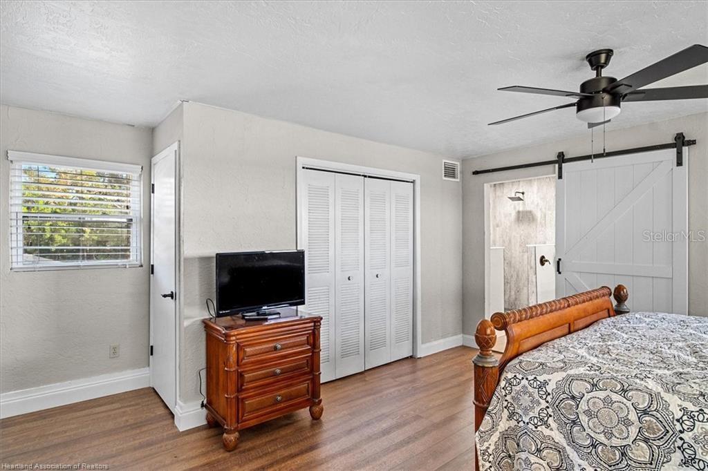 564 Lake June Road Lake Placid, FL 33852 - Photo 27 of 49 a bedroom with furniture and a flat screen tv