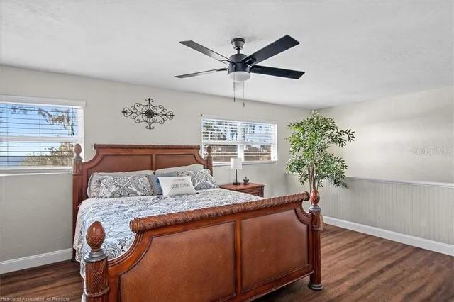 a bed sitting in a bedroom next to a window with a potted plant