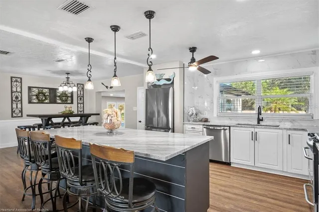 a kitchen with stainless steel appliances granite countertop a stove a sink and a refrigerator