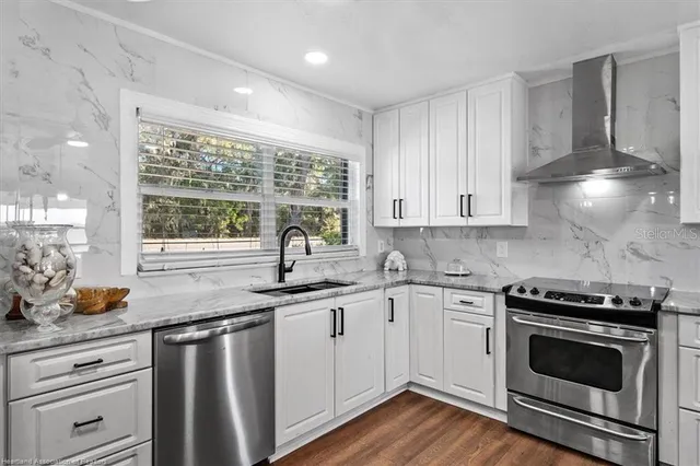 a kitchen with stainless steel appliances white cabinets and a sink