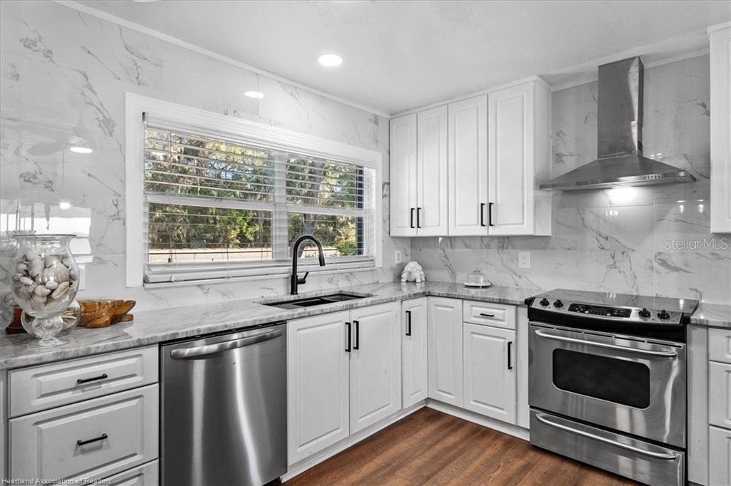 564 Lake June Road Lake Placid, FL 33852 - Photo 34 of 49 a kitchen with stainless steel appliances white cabinets and a sink