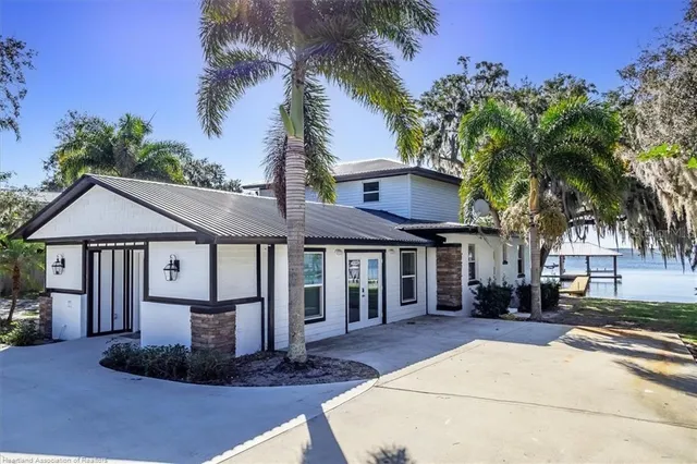a front view of a house with a yard and potted plants