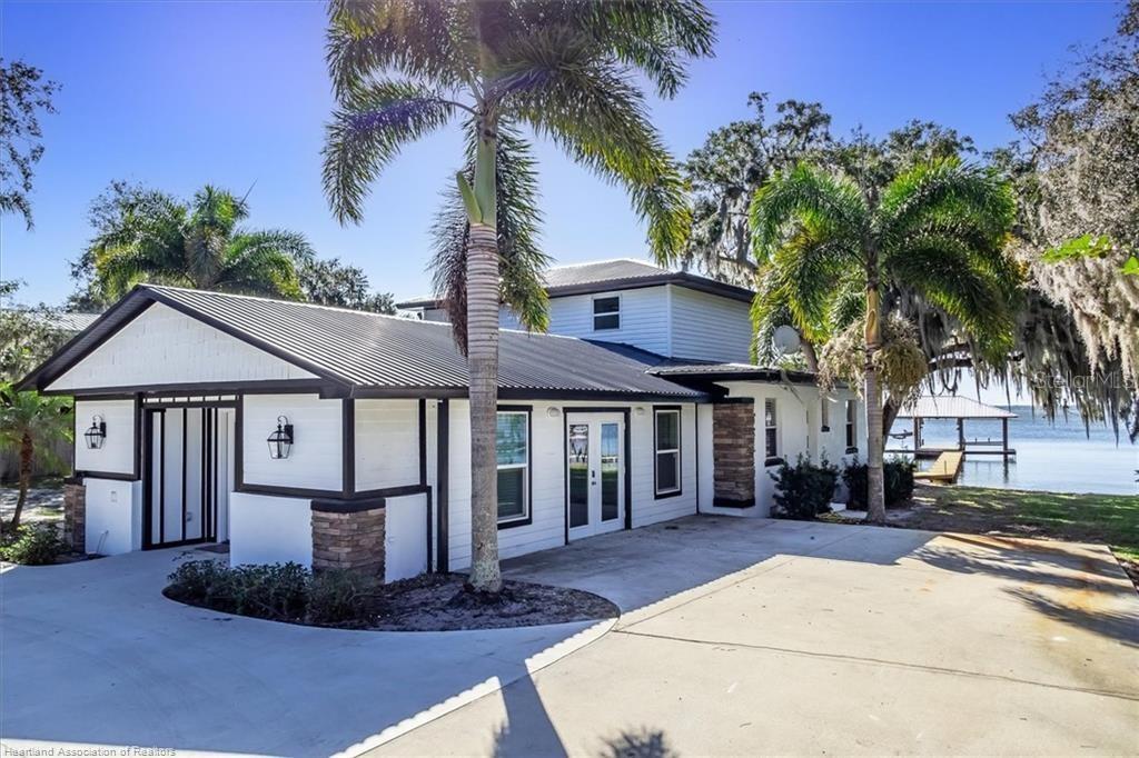 564 Lake June Road Lake Placid, FL 33852 - Photo 49 of 49 a front view of a house with a yard and potted plants