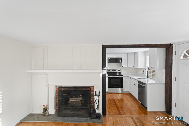 3 Riverside Road, Unit B Newtown, CT 06482 - Photo 4 of 20 a living room with stainless steel appliances furniture a fireplace and wooden floor