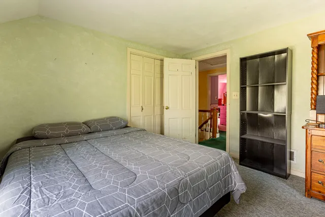 a bedroom with a bed and a refrigerator