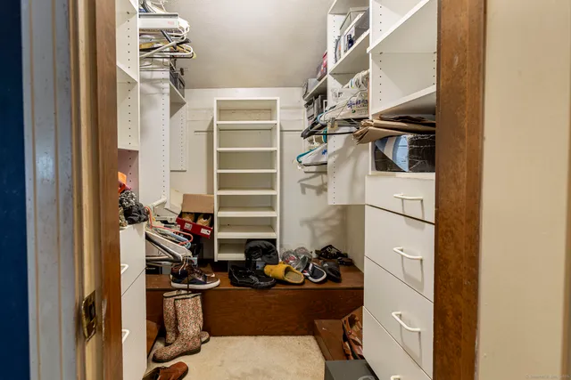 a view of walk in closet with clothes and shoes