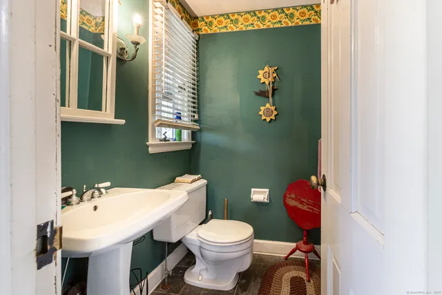 a bathroom with a sink a toilet and mirror