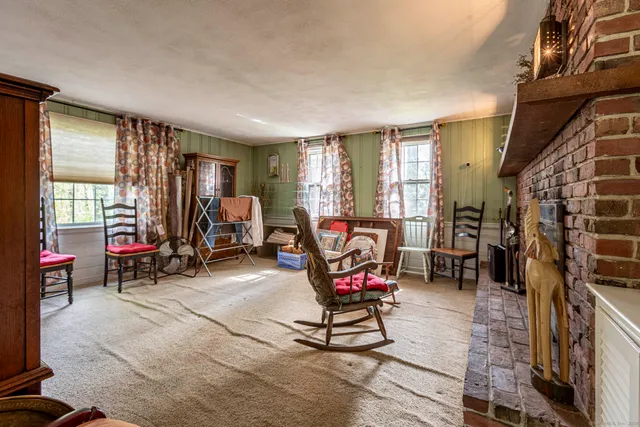 a living room with furniture a flat screen tv and a large window