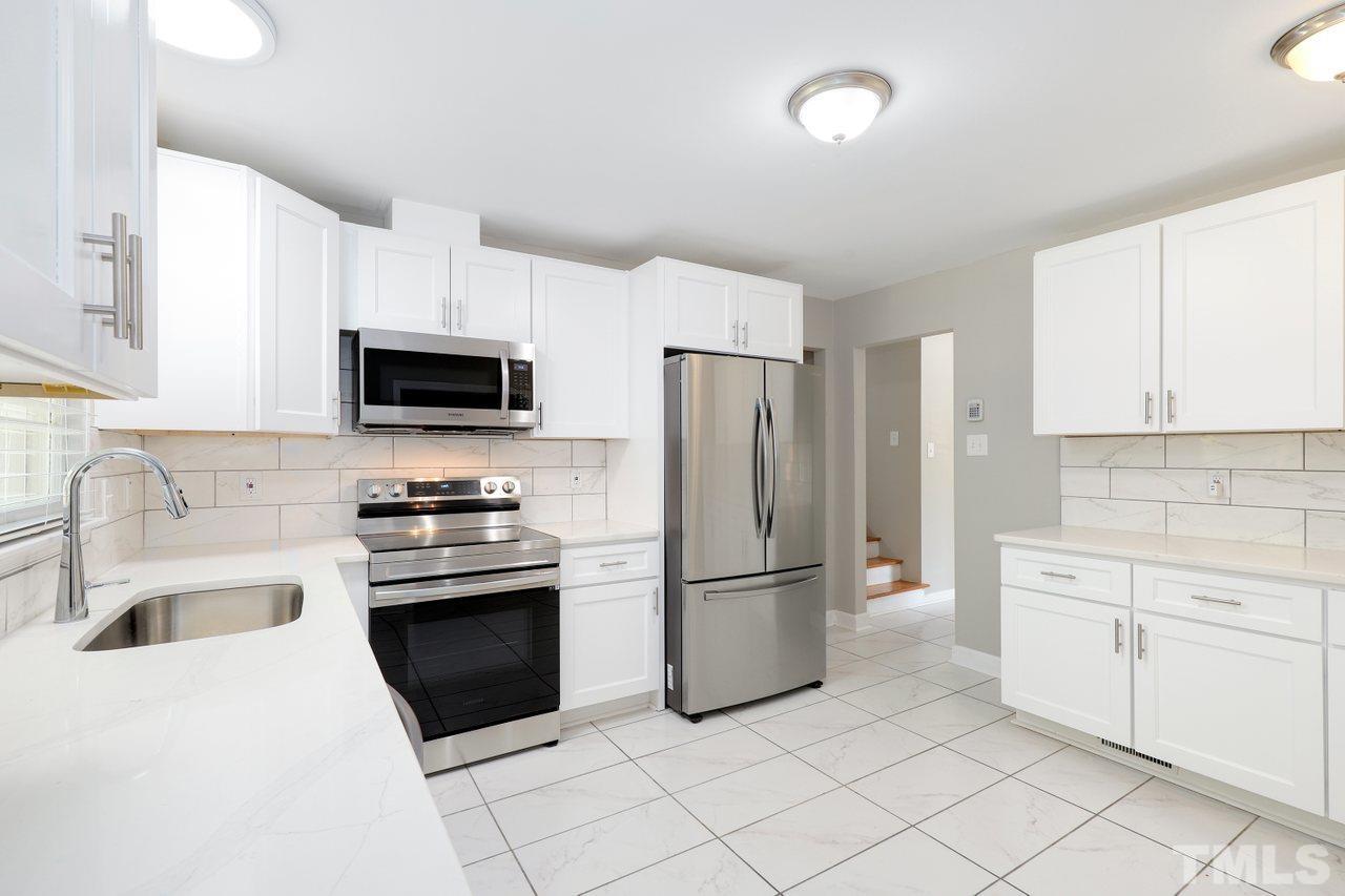 5309 Falls Of Neuse Road Raleigh, NC 27609 - Photo 10 of 38 a kitchen with stainless steel appliances granite countertop a refrigerator stove a sink and dishwasher