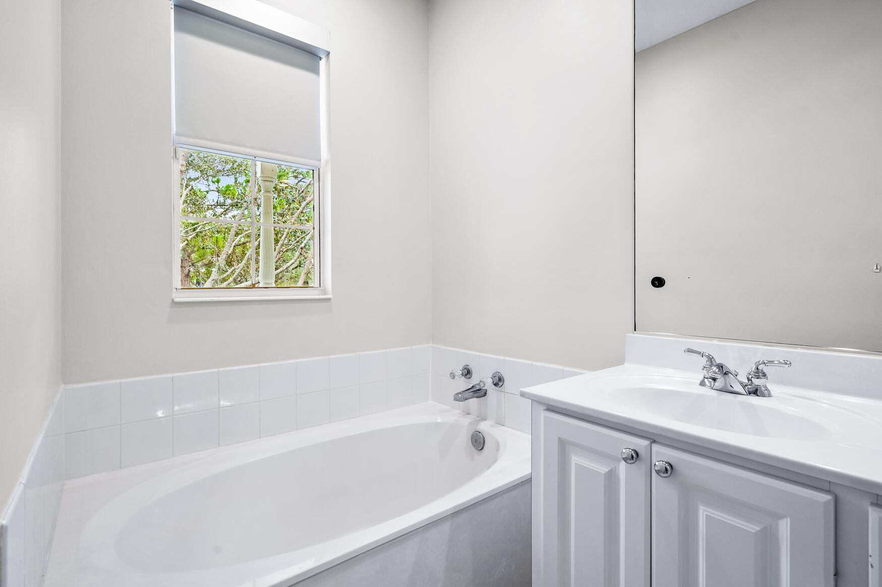 3184 West Community Drive Jupiter, FL 33458 - Photo 21 of 25 a bathroom with a bathtub a shower a sink and a window