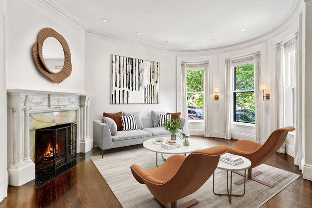 a living room with furniture a fireplace and a large window