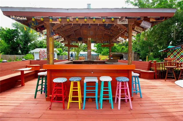 a patio with wooden floor a yard a table and chairs
