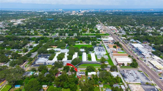 an aerial view of residential houses with outdoor space and trees