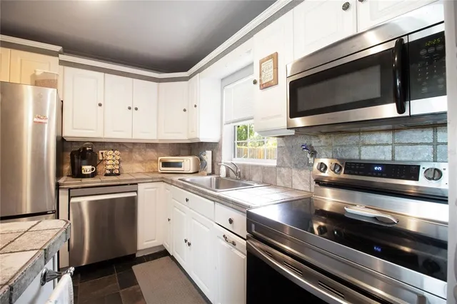 a kitchen with stainless steel appliances and white cabinets