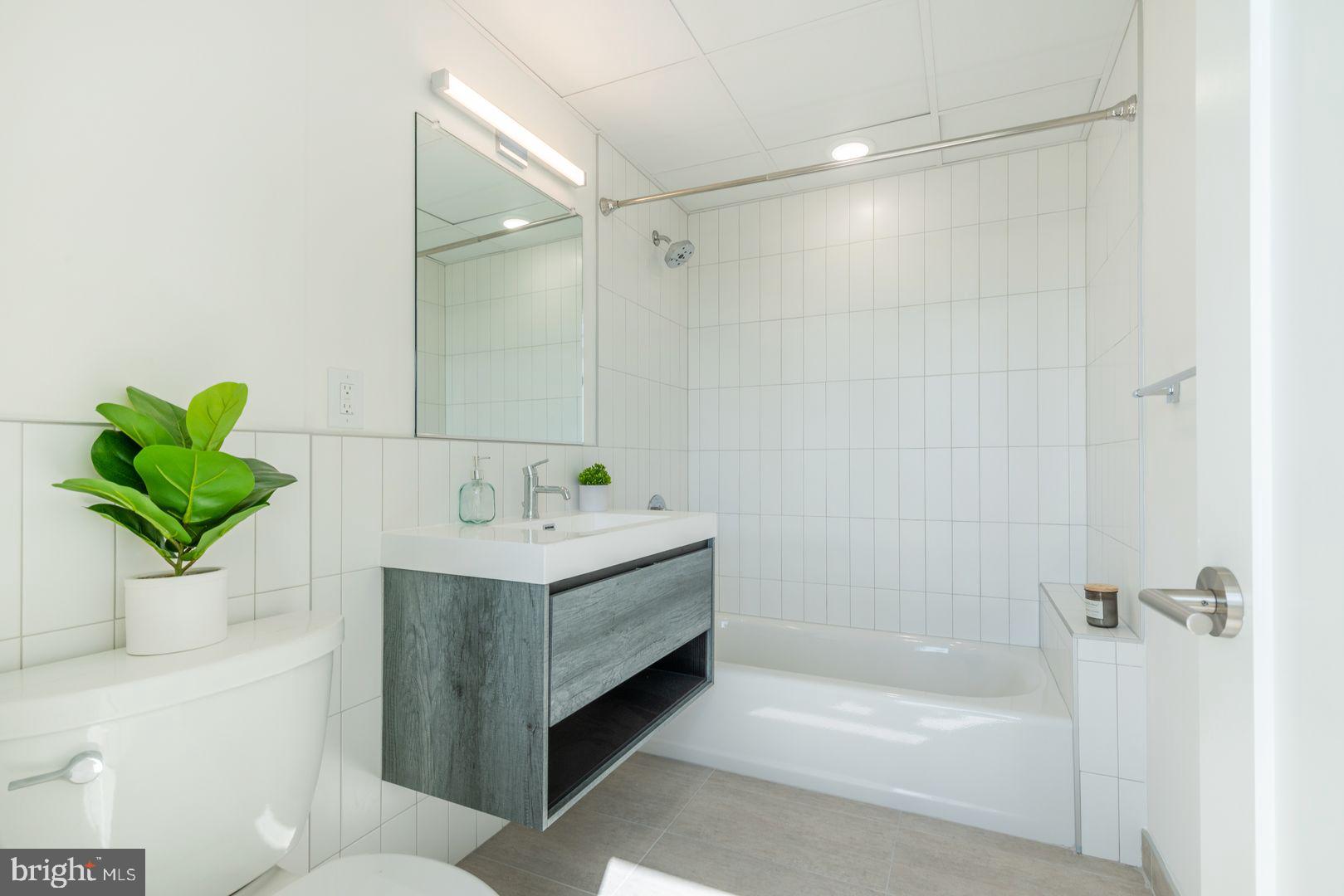 833 Wharton Street, Unit 2B405 Philadelphia, PA 19147 - Photo 13 of 15 a bathroom with a bathtub sink and toilet