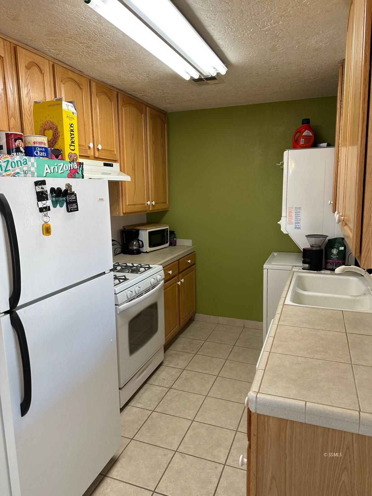 237 South Desert Candles Street Ridgecrest, CA 93555 - Photo 7 of 23 a kitchen with a white stove sink and a refrigerator