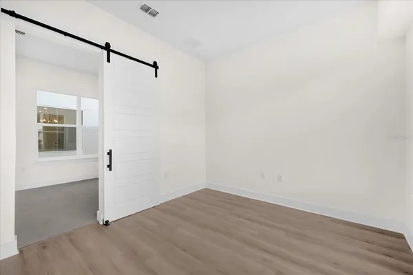 a view of a small space with wooden floor and a ceiling fan