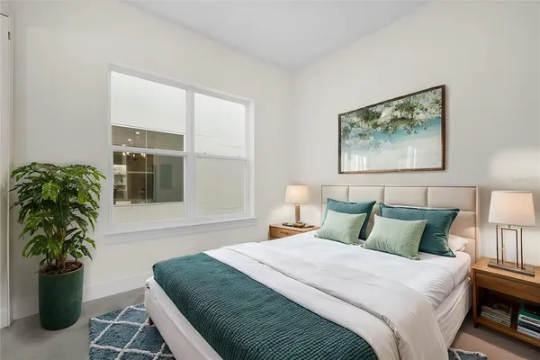 a bedroom with a bed and a potted plant