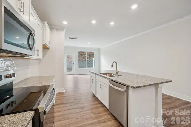 a kitchen with stainless steel appliances granite countertop a sink stove and cabinets