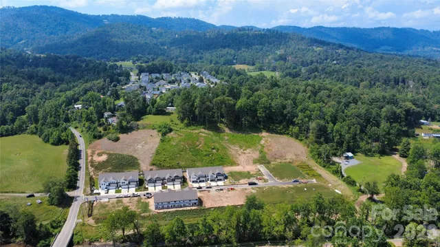 an aerial view of residential house with outdoor space and trees all around