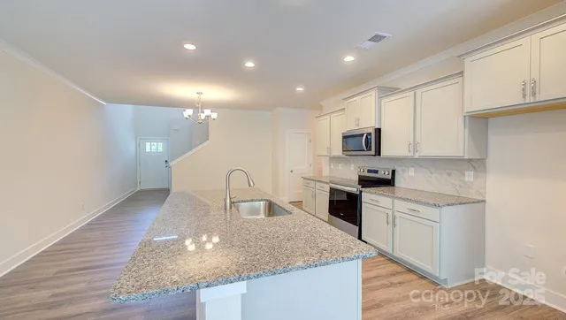 a kitchen with sink a microwave and cabinets