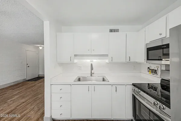 a kitchen with stainless steel appliances a refrigerator sink and microwave