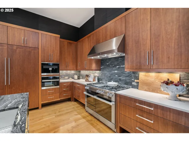a kitchen with kitchen island granite countertop a refrigerator a sink and wooden cabinets