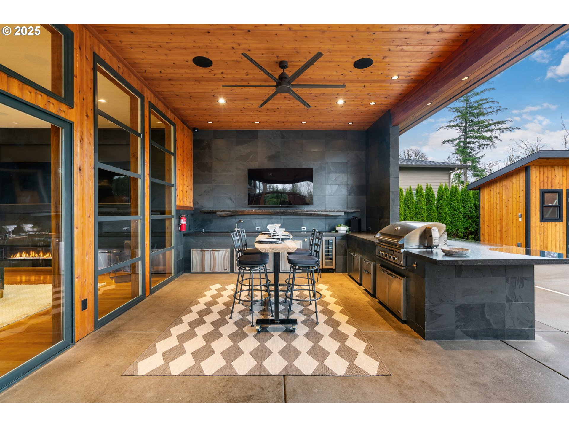 6730 Northwest Longbow Lane Camas, WA 98607 - Photo 37 of 45 a living room with furniture a flat screen tv and a floor to ceiling window