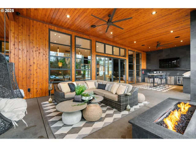 a living room with furniture a flat screen tv and a floor to ceiling window