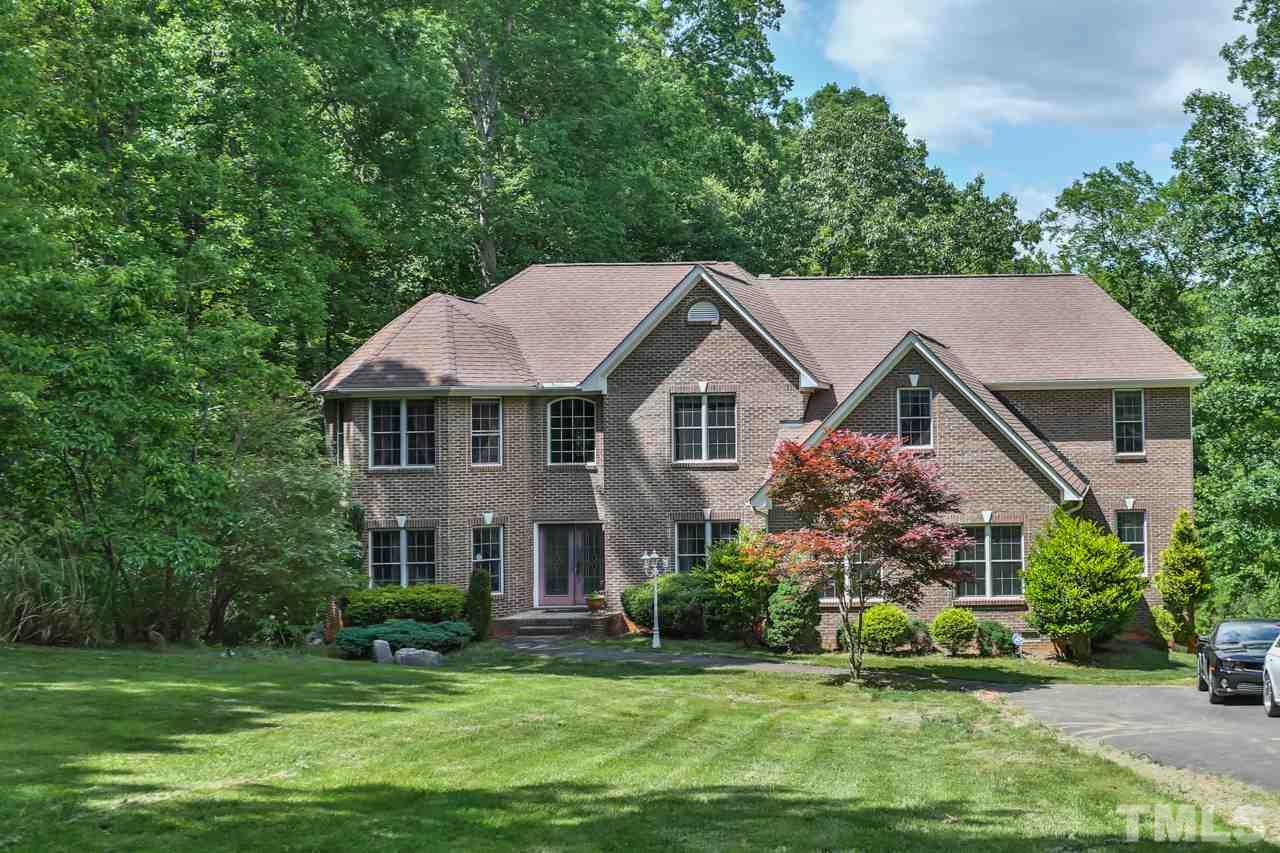 6448 Guess Road Durham, NC 27712 - Photo 1 of 23 a front view of a house with a garden and trees