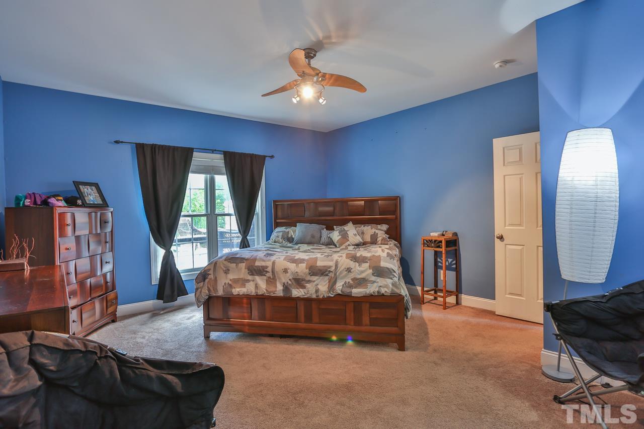 6448 Guess Road Durham, NC 27712 - Photo 11 of 23 a bed sitting in a room next to a lamp with a flat screen tv