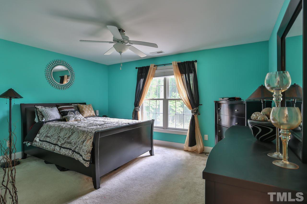 6448 Guess Road Durham, NC 27712 - Photo 19 of 23 a bedroom with a bed windows and a chandelier