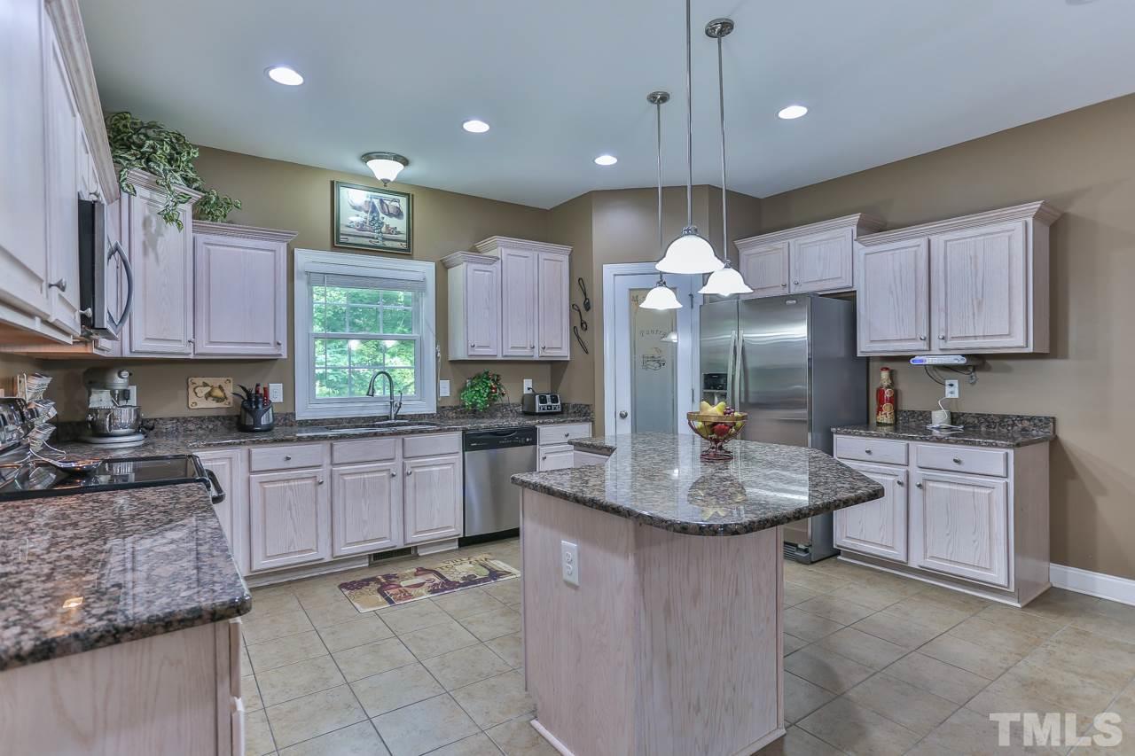 6448 Guess Road Durham, NC 27712 - Photo 7 of 23 a kitchen with kitchen island granite countertop a stove a sink a oven a dining table and chairs