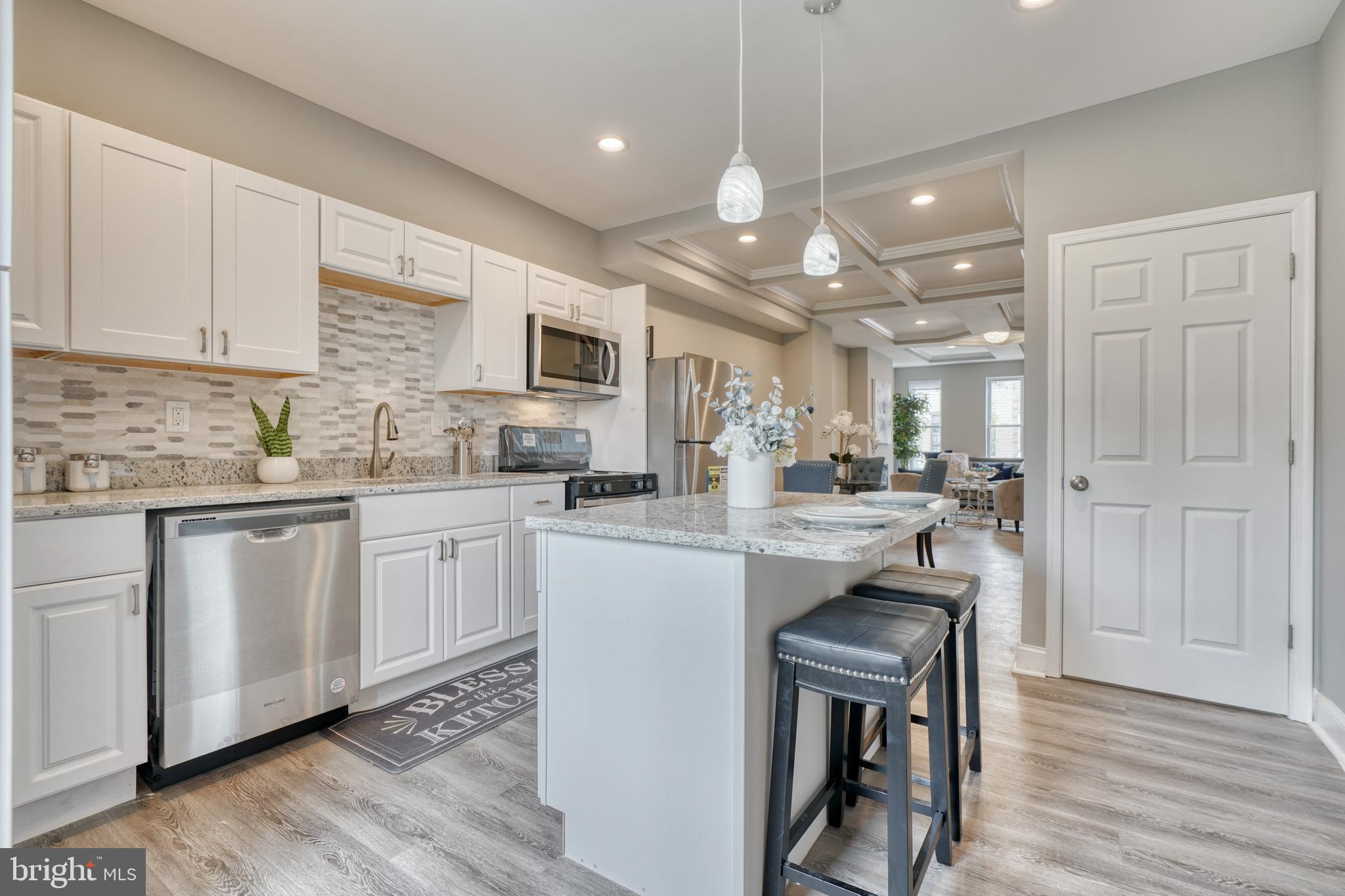 a kitchen with cabinets a sink stainless steel appliances and wooden floor