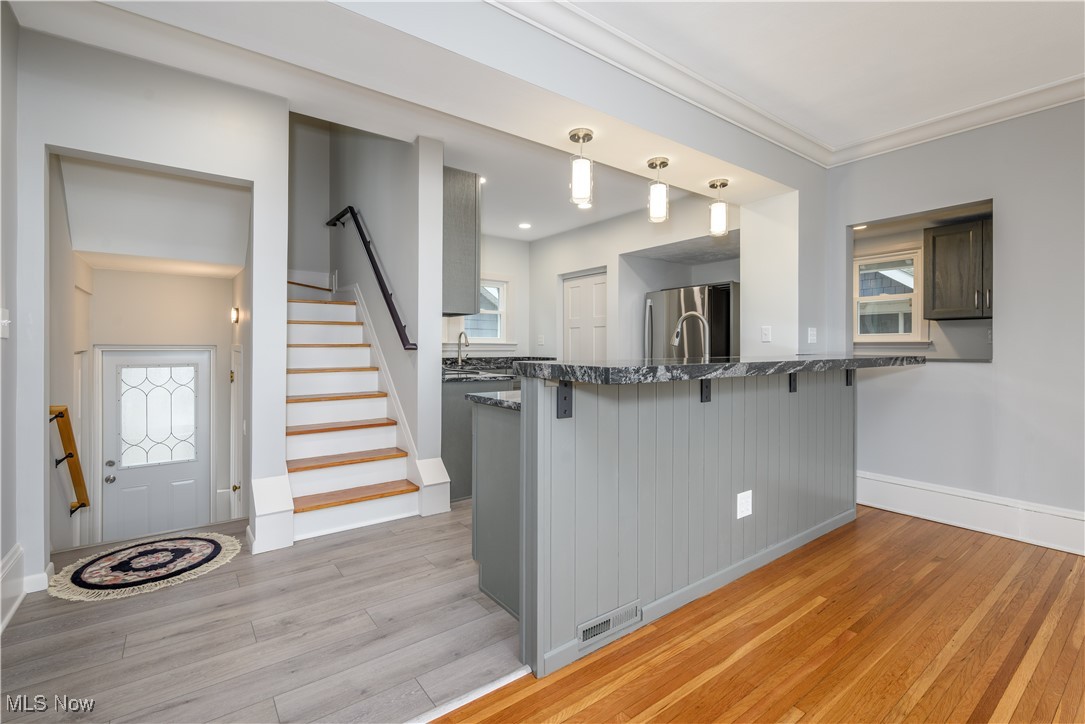 17728 Windward Road Cleveland, OH 44119 - Photo 13 of 32 Kitchen featuring pendant lighting, sink, a breakfast bar area, stainless steel refrigerator, and kitchen peninsula