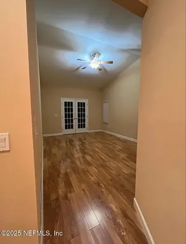 a view of empty room with wooden floor
