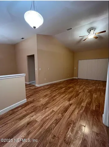 a view of empty room with wooden floor