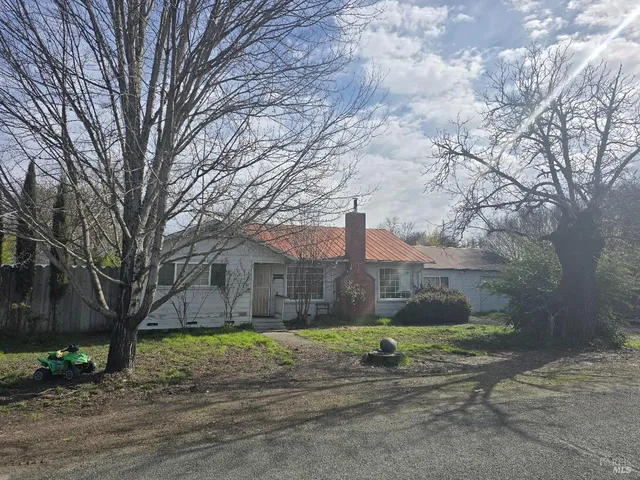 a view of a road with large trees