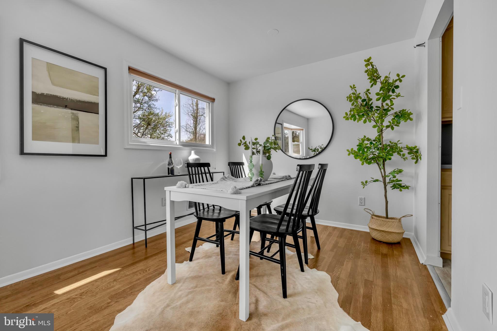 9807 Locust Avenue Lanham, MD 20706 - Photo 18 of 59 a dining room with furniture and a potted plant