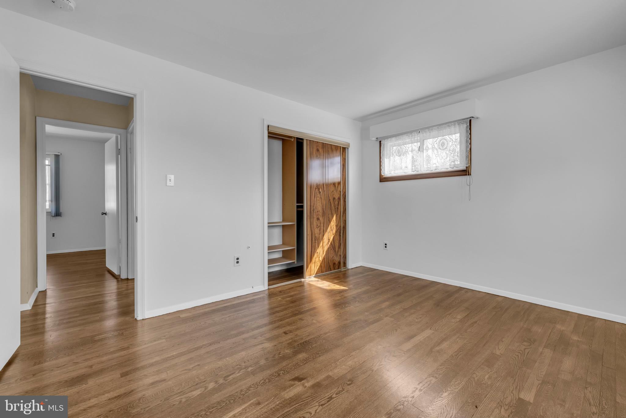 9807 Locust Avenue Lanham, MD 20706 - Photo 27 of 59 a view of an empty room with wooden floor and a window